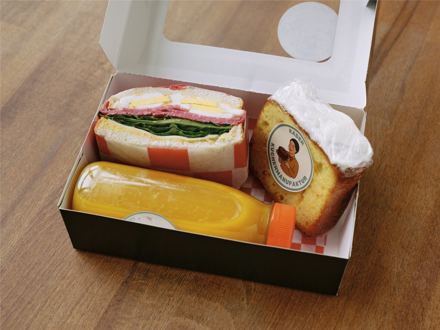 Die kleine klassische Frühstücksbox mit Sandwich, Kuchen und Orangensaft